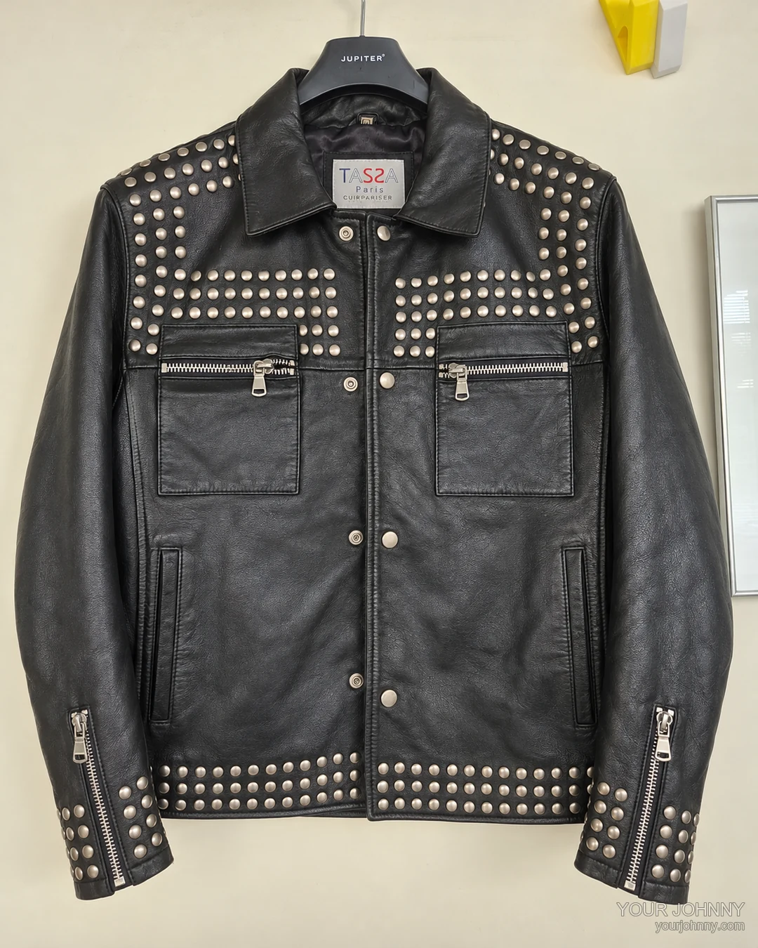 Zwarte vintage jas met studs en ritsen op een hanger