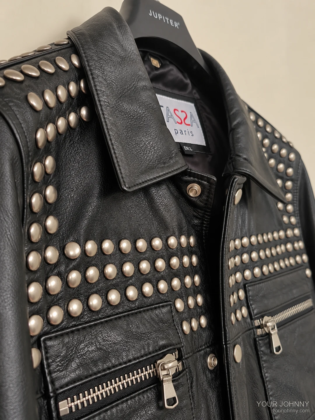 Detail van de kraag, studs en ritszakken van een zwarte vintage jas