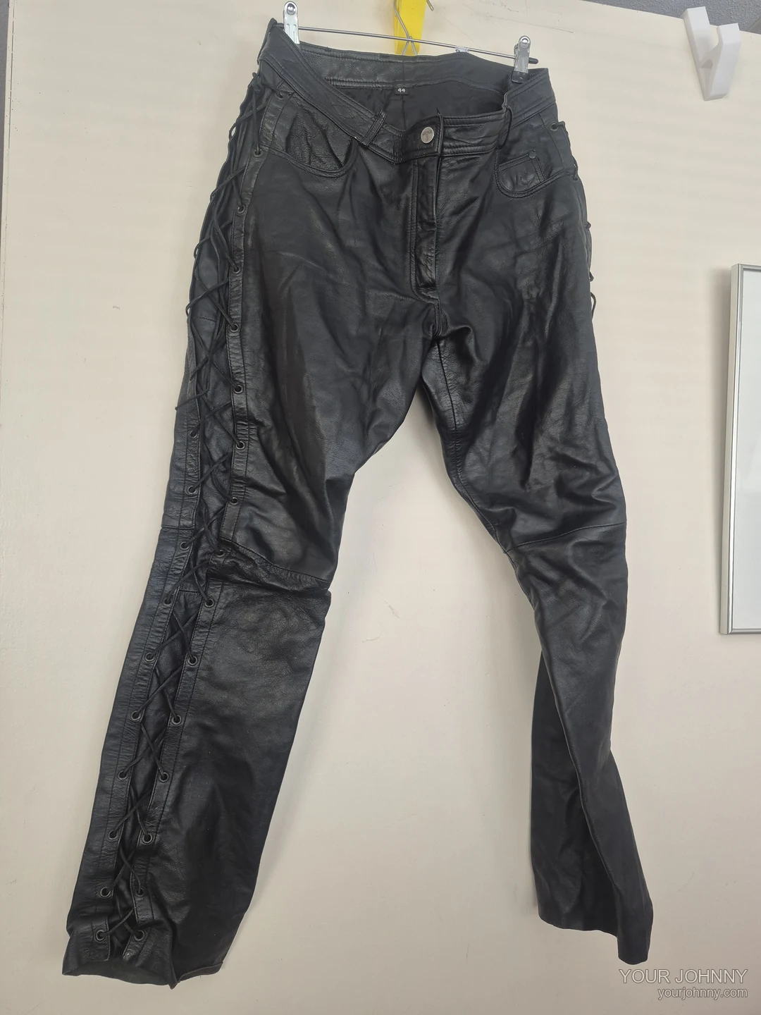 Zwarte vintage broek met veterdetails langs de zijkanten op een hanger