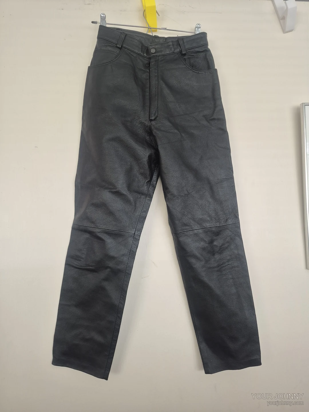 Tweede aanzicht van een zwarte vintage broek met rechte pijpen op een hanger