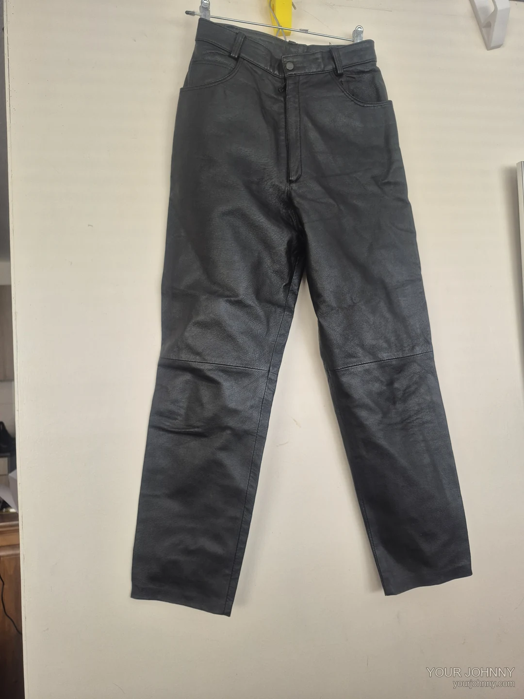 Zwarte vintage broek met rechte pijpen en een naad bij de knieën op een hanger